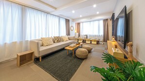 Una sala de estar moderna con sofá, mesa de centro y televisor.
