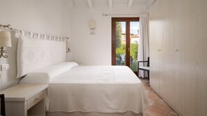 Une chambre à coucher avec un lit, une table de chevet et une vue sur l’extérieur.