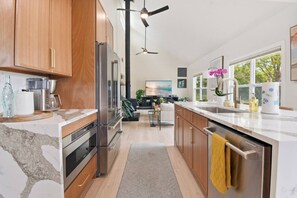 Una cocina moderna con armarios de madera, electrodomésticos de acero inoxidable y una isla grande con una toalla amarilla.