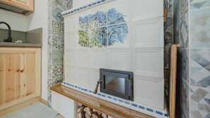 A kitchen with wooden cabinets, a tiled backsplash with a floral pattern, and a built-in microwave. - I Folli di Alleghe Apartment - Parking (Caprile)