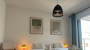 A hotel room with two beds, a chair, a lamp, and two framed pictures on the wall. - Spacious and elegant T4, city center (Vannes)