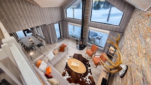Un interior moderno con chimenea, ventanas amplias y pared de piedra.