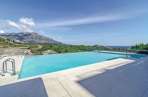 A swimming pool with a view of mountains and a clear sky. - RLQ - Modern 2 Bed Apt With Rooftop Plunge Pool (Benahavis)