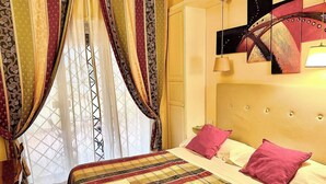 A bed with a quilt, pillows, and a bedside table. - Double with Terrace (Roma)