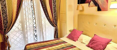 A bed with a quilt, pillows, and a bedside table.