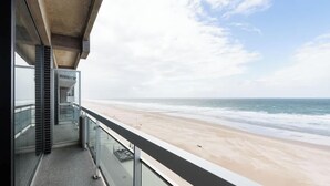 Ein Balkon mit Blick auf Strand und Meer.
