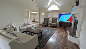 A living room with a sofa, armchairs, a coffee table, and a television. - Spacious 5BR Fayetteville Retreat w/ 6 Beds  10 Min to Campus (Fayetteville)