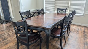 A dining area with a rectangular wooden table surrounded by six chairs with a dark finish. - Spacious 5BR Fayetteville Retreat w/ 6 Beds  10 Min to Campus (Fayetteville)