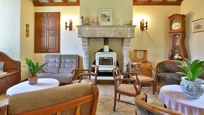 Una sala de estar acogedora con chimenea, muebles de madera y un reloj.