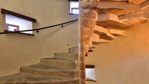 Una escalera de caracol con paredes de piedra y barandilla.