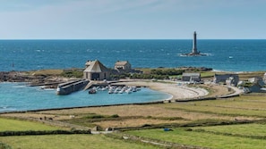 A coastal town with a lighthouse, harbor, and buildings.