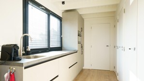 A modern kitchen with a window, a sink, and a countertop. - Stylish Boathouse on Lake Sneeker (Offingawier)