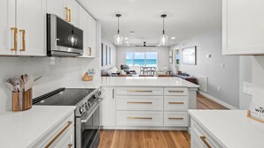 A modern kitchen with white cabinetry, stainless steel appliances, and a central island. - Fully Remodeled First-Floor Condo | Steps to Beach | Siesta Key (Sarasota)