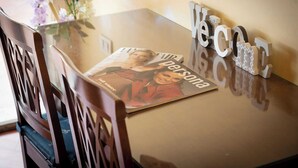A magazine on a glass table, wooden chairs, and a 'Welcome' sign. - Superior Double with Terrace (Roma)