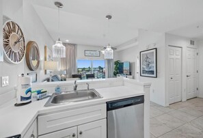 A modern kitchen with a central island, stainless steel appliances, and pendant lighting. - Amazing Newer Condo in Madeira Beach just steps from the Ocean and John's Pass! (Madeira Beach)