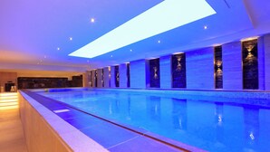 A long indoor swimming pool with a skylight above, tiled walls, and a tiled floor. - Best Plus Aurora Hotel (Riyadh)