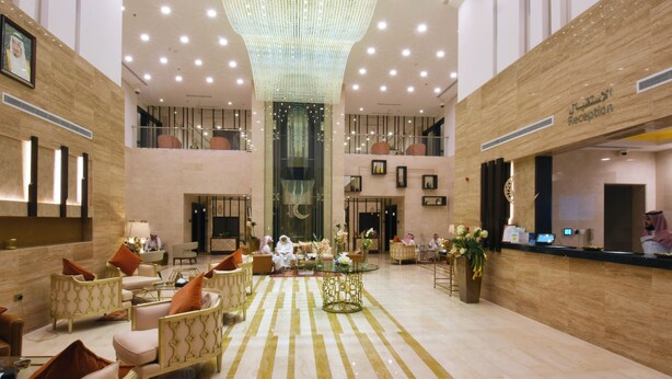 A spacious lobby with a reception desk, seating area, and a chandelier. - Best Plus Aurora Hotel (Riyadh)