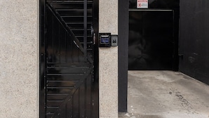 A black elevator door with a stairwell, a number sign '237', and a green emergency exit sign. - ZEST Cardeal (São Paulo)