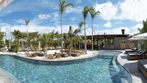 A pool area with lounge chairs and palm trees. - Villa Ya Huru & Mistico Beach Club + Boat Shuttle (San Pedro)