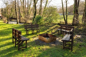 A park with wooden benches and a fire pit. - Cabin No. 14 - Salt and Fern Cabins (Port Talbot)