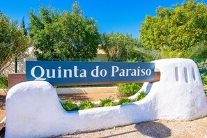 A sign with 'Quinta do Paraíso' written on it, placed on a white bench with a curved backrest. - C59 Quinta do Paraiso -  Perfect Algarve escape with private garden and terraces (Carvoeiro)