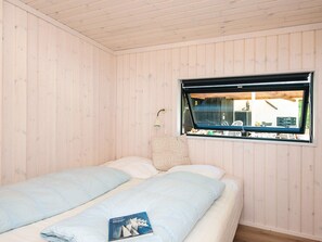 A room with two beds, a window with a view, and a lamp. - 5 Star Holiday Home in Hejls (Hejls)