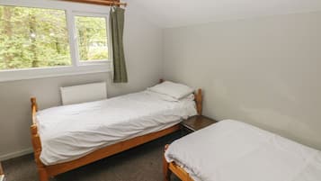 Una habitación pequeña con cama individual, ventana y radiador.