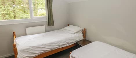 A small, single-bed room with a window and a radiator.