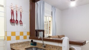A kitchen with a granite countertop, wooden cabinets, a stainless steel sink, a coffee maker, and a mirror above the sink. - 15min From Flamengo Beach Oc107b (Rio de Janeiro)
