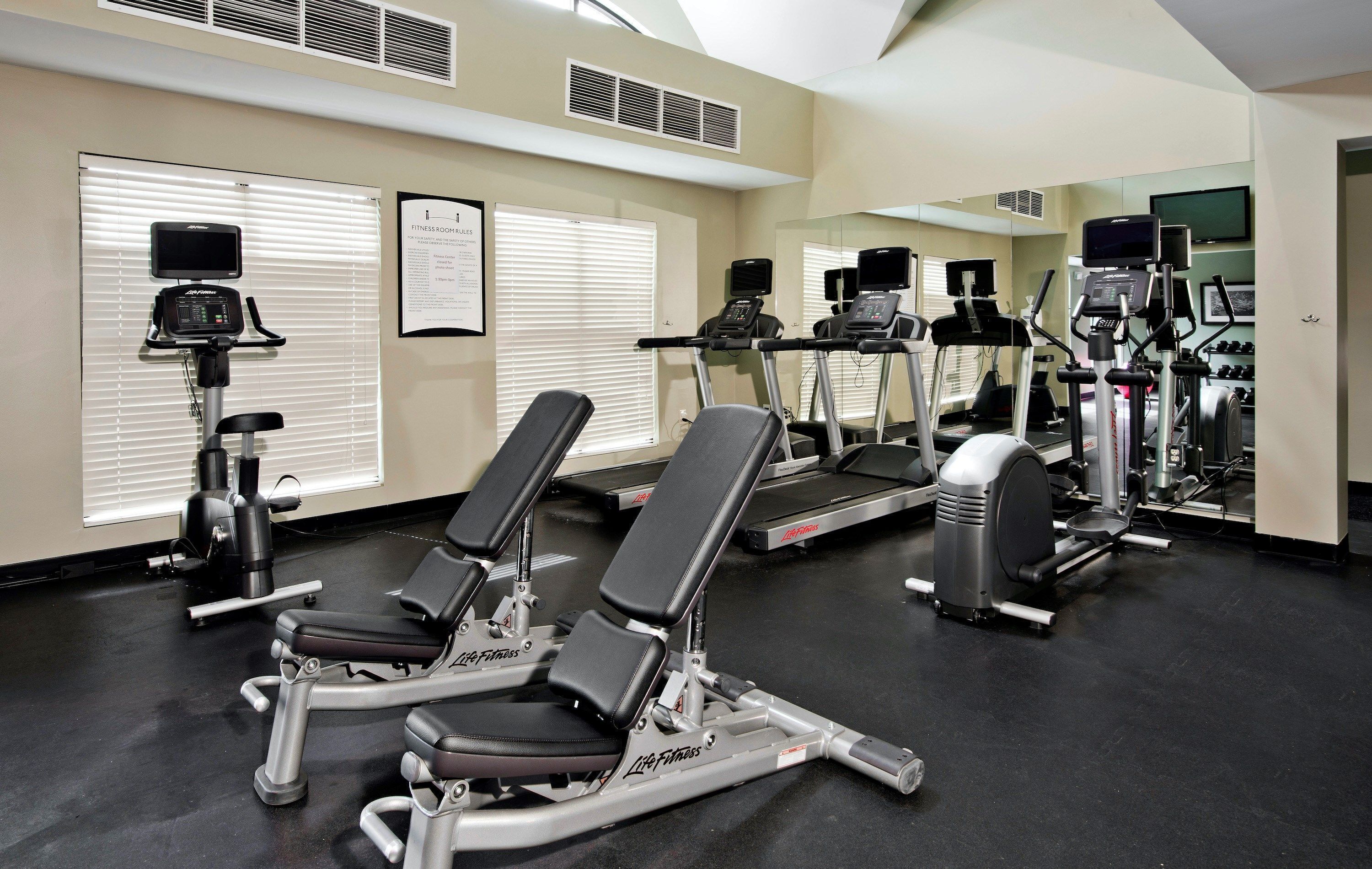 Une salle de sport équipée de matériel d’exercice, d’un tapis de course et d’un vélo d’appartement.