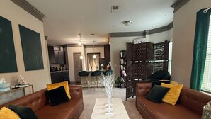 A living room with brown leather sofas, a white coffee table, and a ceiling fan. - Velvet Vibes Retreat - A Corporate Work, Play, Stay Getaway (Pooler)