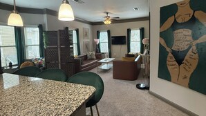 A modern kitchen with granite countertops, bar stools, and pendant lighting. - Velvet Vibes Retreat - A Corporate Work, Play, Stay Getaway (Pooler)