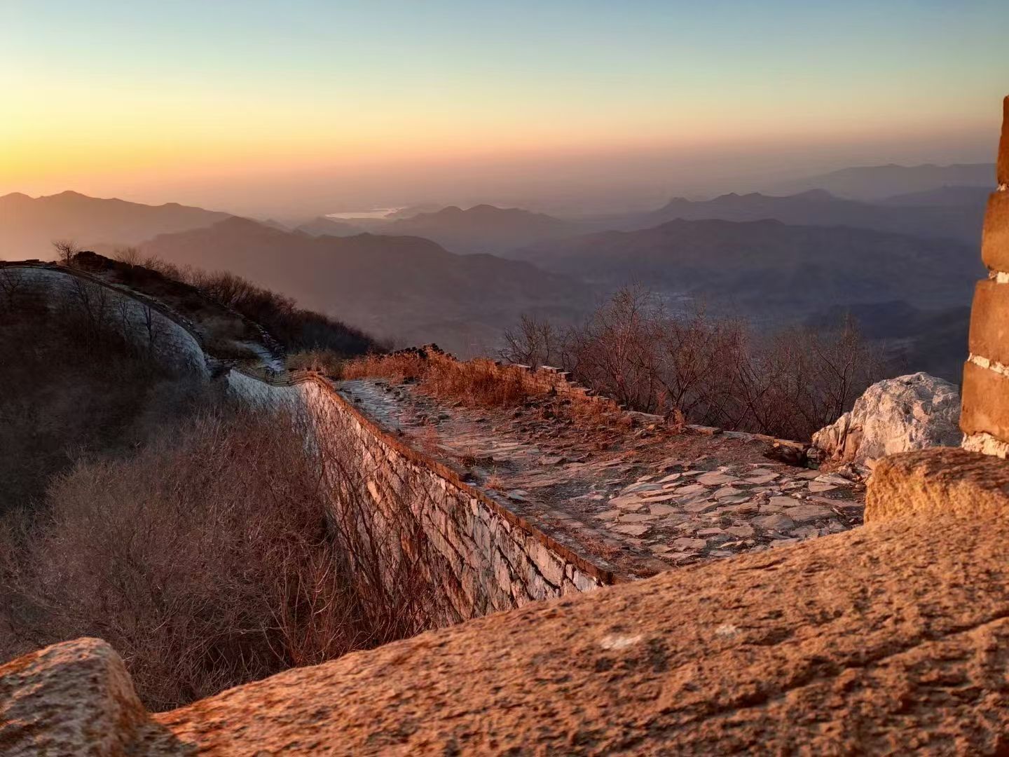 A stone pathway leading to a mountainous landscape with a clear sky.