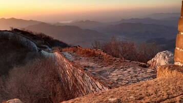 A stone pathway leading to a mountainous landscape with a clear sky.