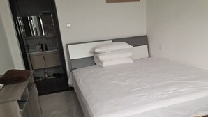 A neatly arranged bedroom with a bed, a small desk, and a mirror. - Near Mutianyu Country Villa (Huairou)