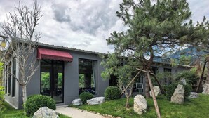 A modern building with a red awning, large windows, and a pathway leading to the entrance. - Near Mutianyu Country Villa (Huairou)