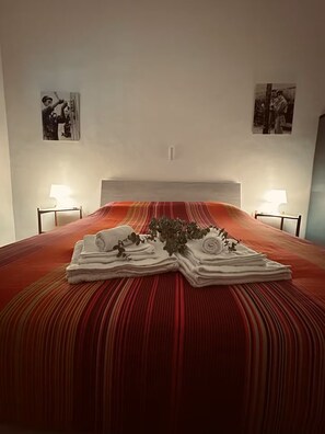 Ein Hotelzimmer mit einem Bett, zwei Nachttischen, einem Kopfteil und zwei Bildern an der Wand.