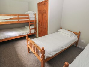 A room with bunk beds, a wooden door, and a carpeted floor. - Cabin No. 13 - Salt and Fern Cabins (Port Talbot)