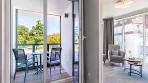 Um apartamento moderno com varanda, um sofá e uma pequena mesa.