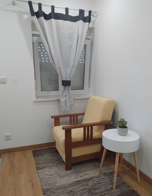A corner room with a window, a chair, a small table with a plant, and a rug. - Apartment in a residential area 900 m from the center of São Pedro de Alva (São Pedro de Alva)