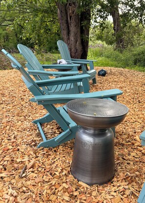 Buiten zitplaatsen met Adirondack-stoelen en een metalen tafel.