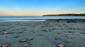 A beach with scattered rocks, calm water, and a distant shoreline. - Stylish Artist Cottage Near Beach &Plimoth Patuxet (Plymouth)