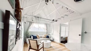 A modern living room with a white ceiling, a sofa, a coffee table, and a large window. - Stylish Artist Cottage Near Beach &Plimoth Patuxet (Plymouth)