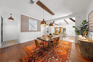 A dining area with a wooden table, chairs, pendant lights, and a patterned rug. - Poplar Place Main - Hot Tub & Fire Pit (Fredericksburg)