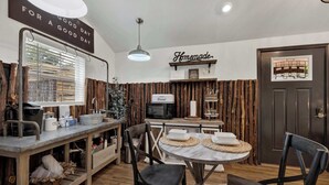 A kitchen with a wooden wall, a microwave, a bread box, and a sign that says 'Homemade.' - Poplar Place Soho - Cozy Cottage with Hot tub (Fredericksburg)