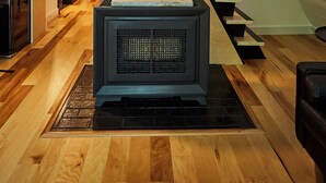 Ein modernes Interieur mit einer Holztreppe, einem großen Heizkörper und einer Küchenzeile.