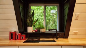 Eine Küche mit Fenster, Spüle und Schränken.