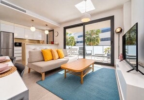 A modern living space with a sofa, dining table, and a balcony with outdoor furniture. - Arenal Dream Glow Apartment Jávea (Javea / Xàbia)