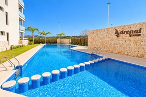 A swimming pool with steps leading into it, surrounded by a stone wall and a building. - Arenal Dream Glow Apartment Jávea (Javea / Xàbia)