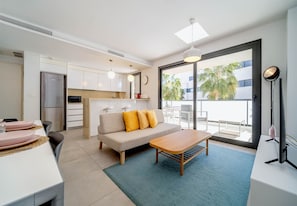 Un espace de vie moderne comprenant une cuisine, un coin repas, un canapé et un balcon avec vue.